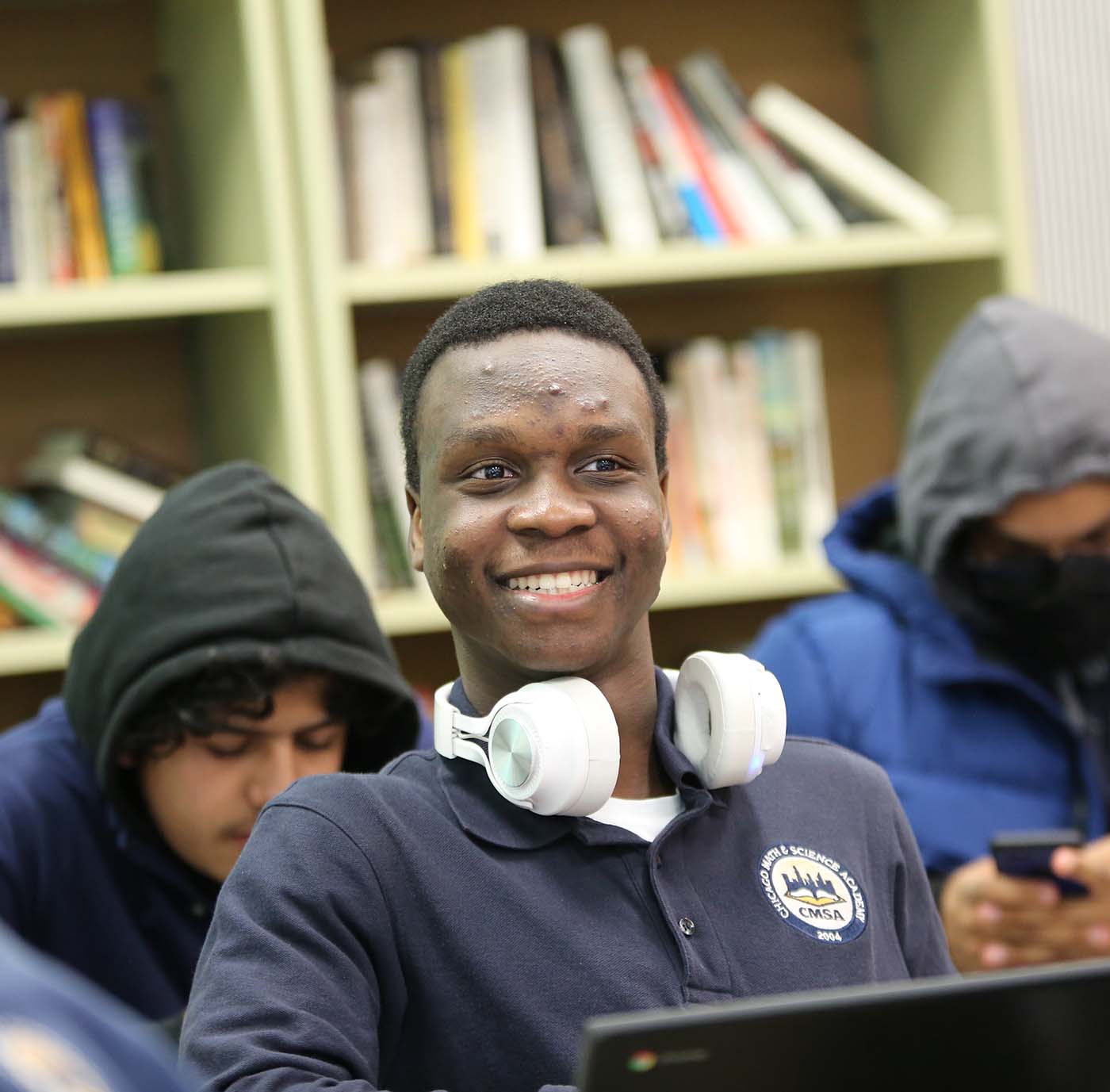 CMSA student drawing at a desk in a classroom setting